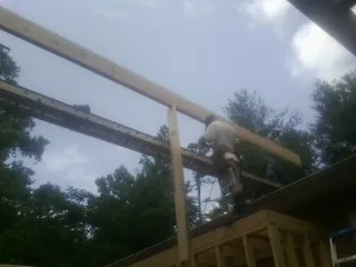 Carpenter setting a ridge beam over a new addition frame — Ice Dam Removal by Roofing Brothers in Thornville