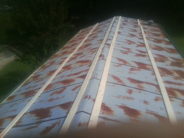Rusted metal roof panels with new wood purlins before replacement — Storm Damage Roof Repair in Thornville by Roofing Brothers