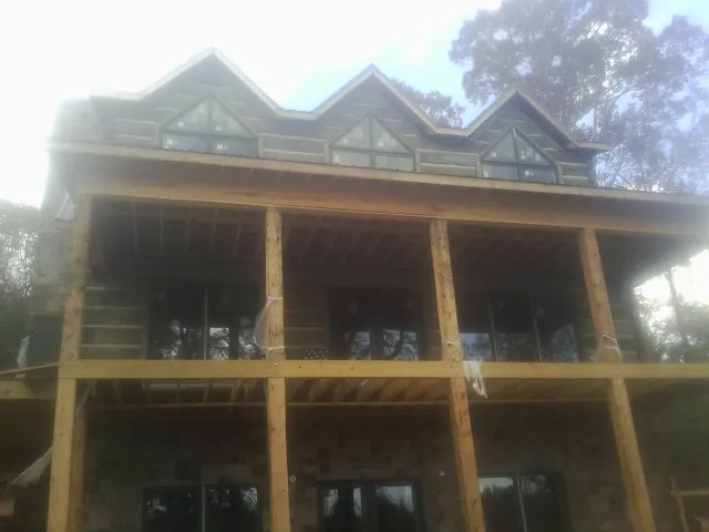 Dormers and porch framing on a large log home under construction — Roof Coating work by our crew in Thornville