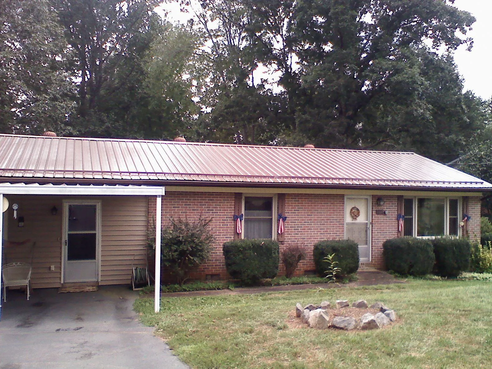 Bronze metal roof and carport on a brick ranch home — Roof Repair work by our crew in Thornville